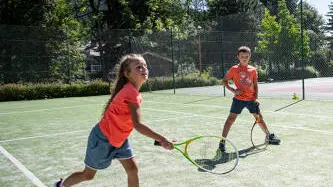 photo de 2 enfants en train de jouer au tennis