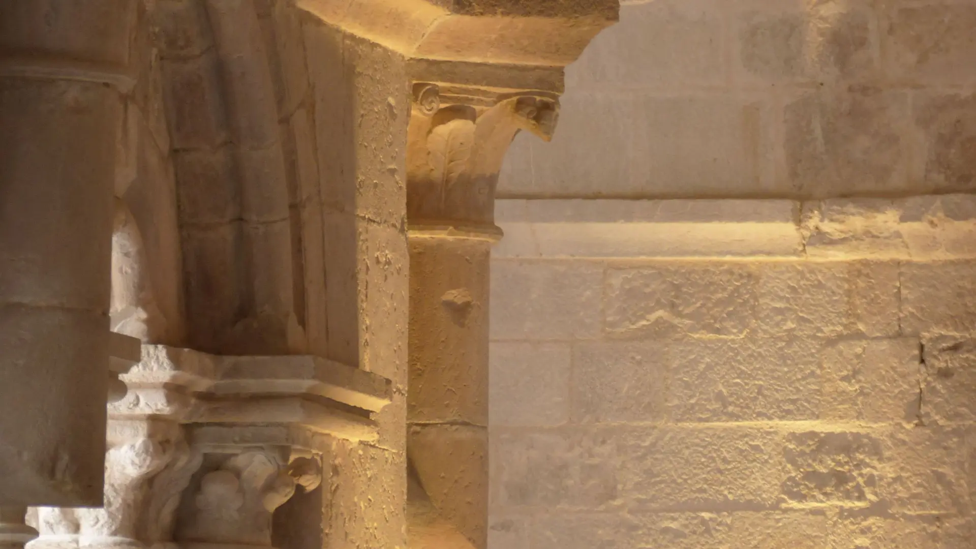 Vue sur un pilier intérieur en pierre de l'abbaye de la Celle avec une mise en lumière des détails des corniches et moulures