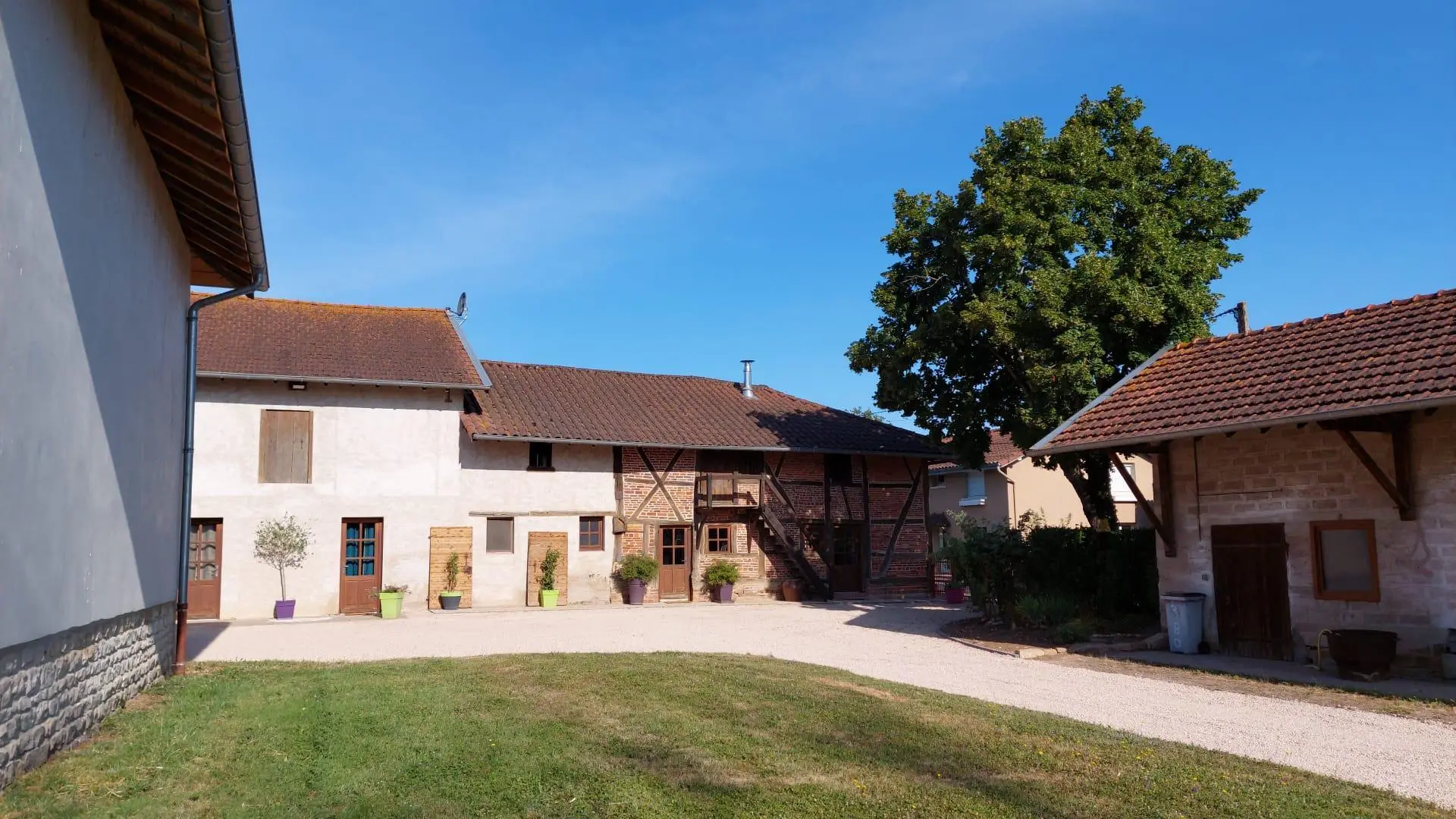 Façade de la grande ferme bressane. Accès à la cour par un chemin privatif (dépendances disponibles pour ranger vos vélos)