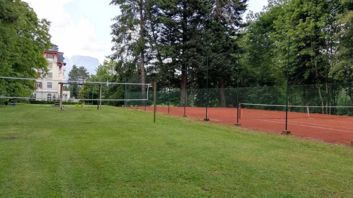 Terrain de tennis en terre battue et badminton.