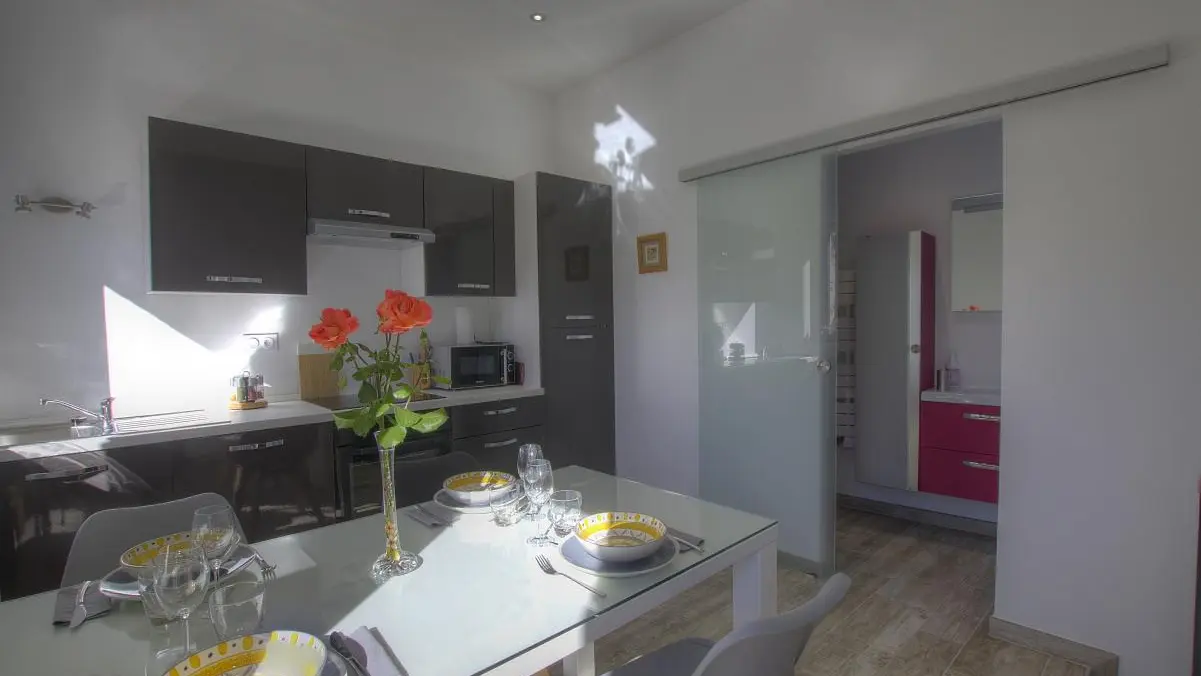 Cuisine très bien équipée avec porte coulissante sur la salle d'eau.