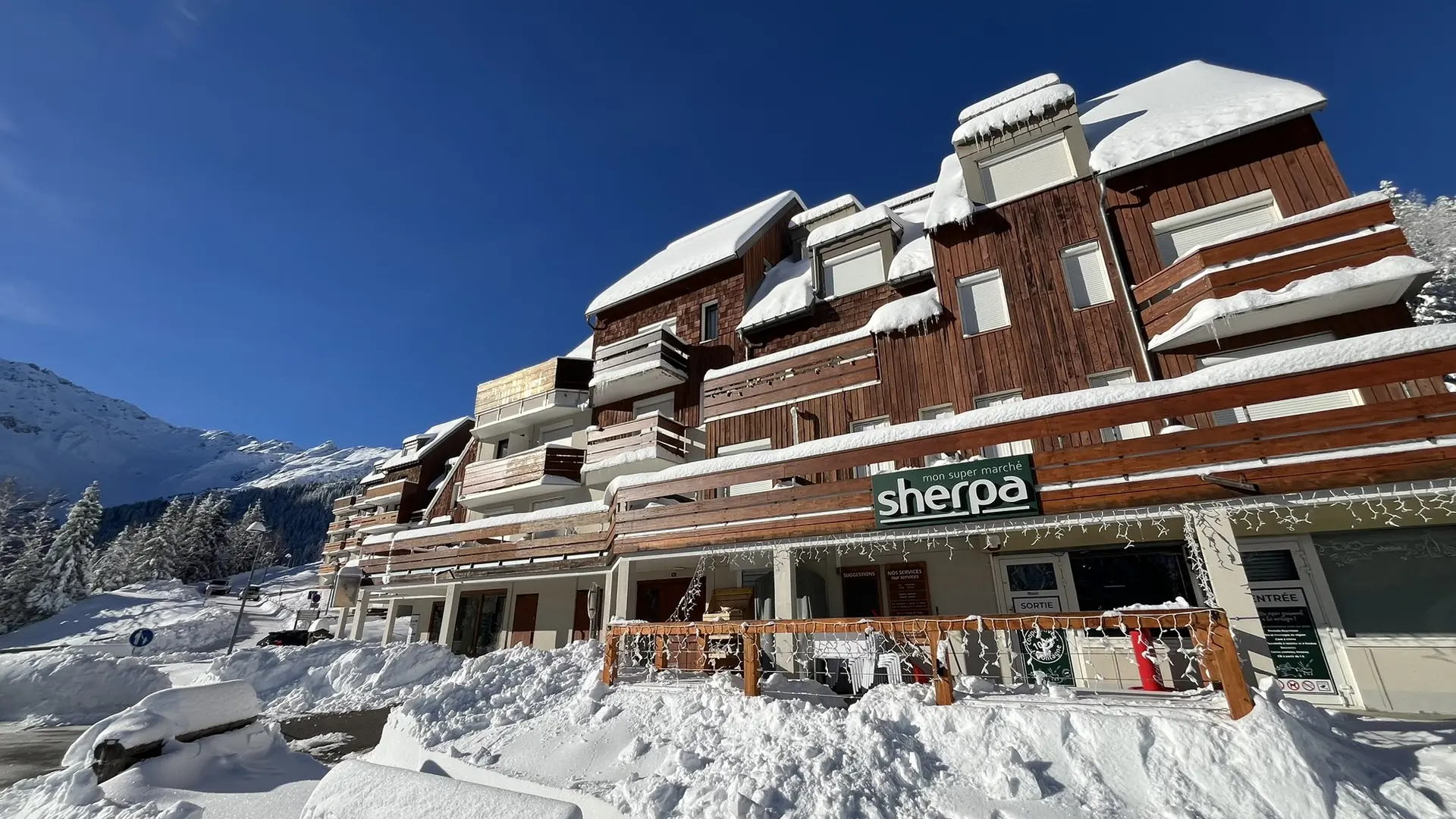 Devanture supérette le Sherpa du Pleynet en hiver vue depuis le parking
