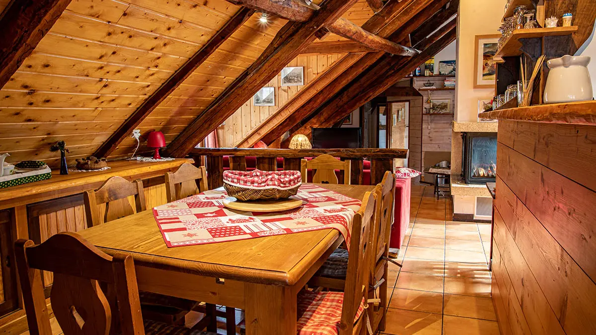 Attic living room with table and chairs, kitchen bar and wooden furniture