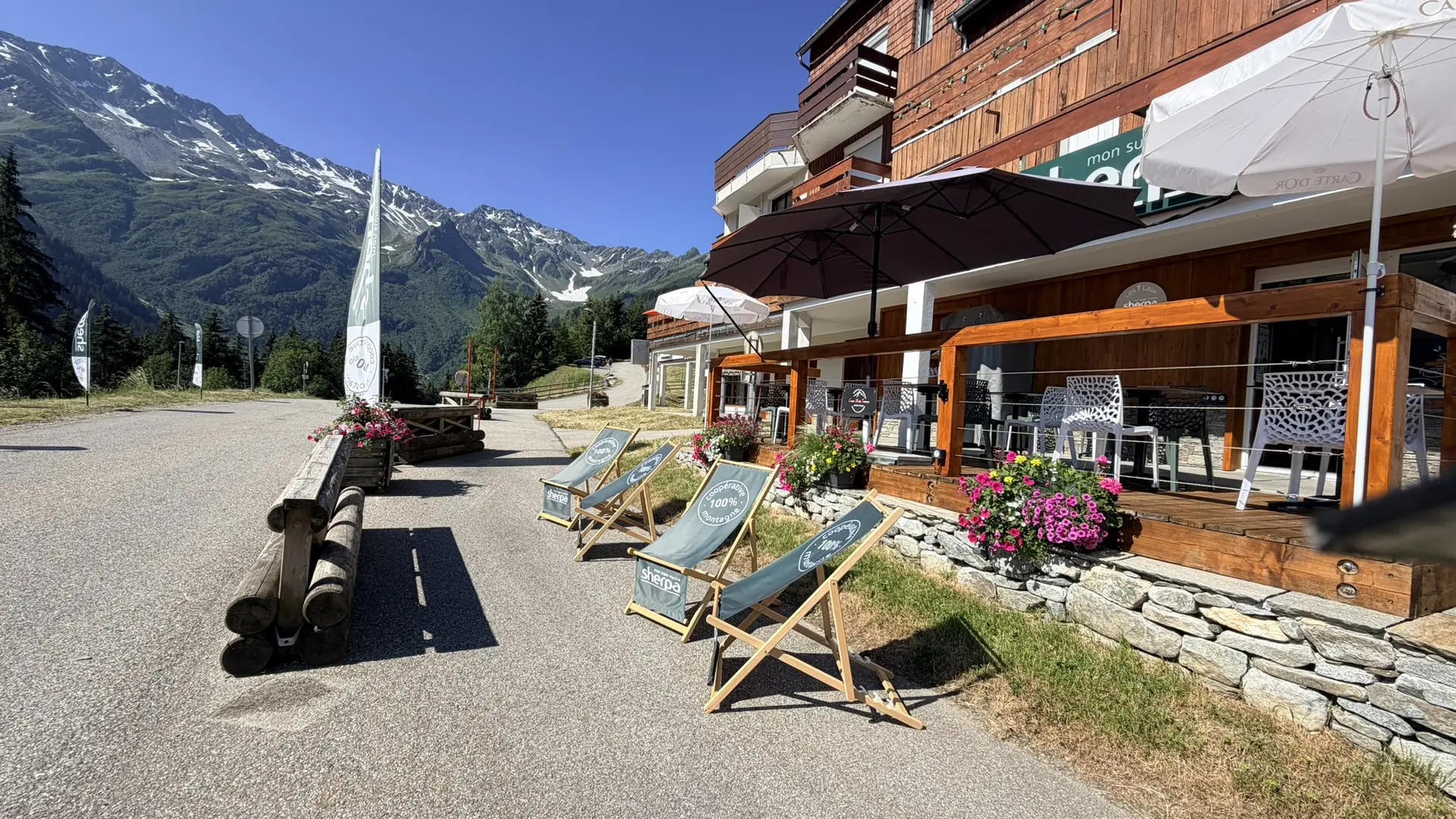 Devanture épicerie Le Sherpa en été avec des chaises longues instalées au soleil