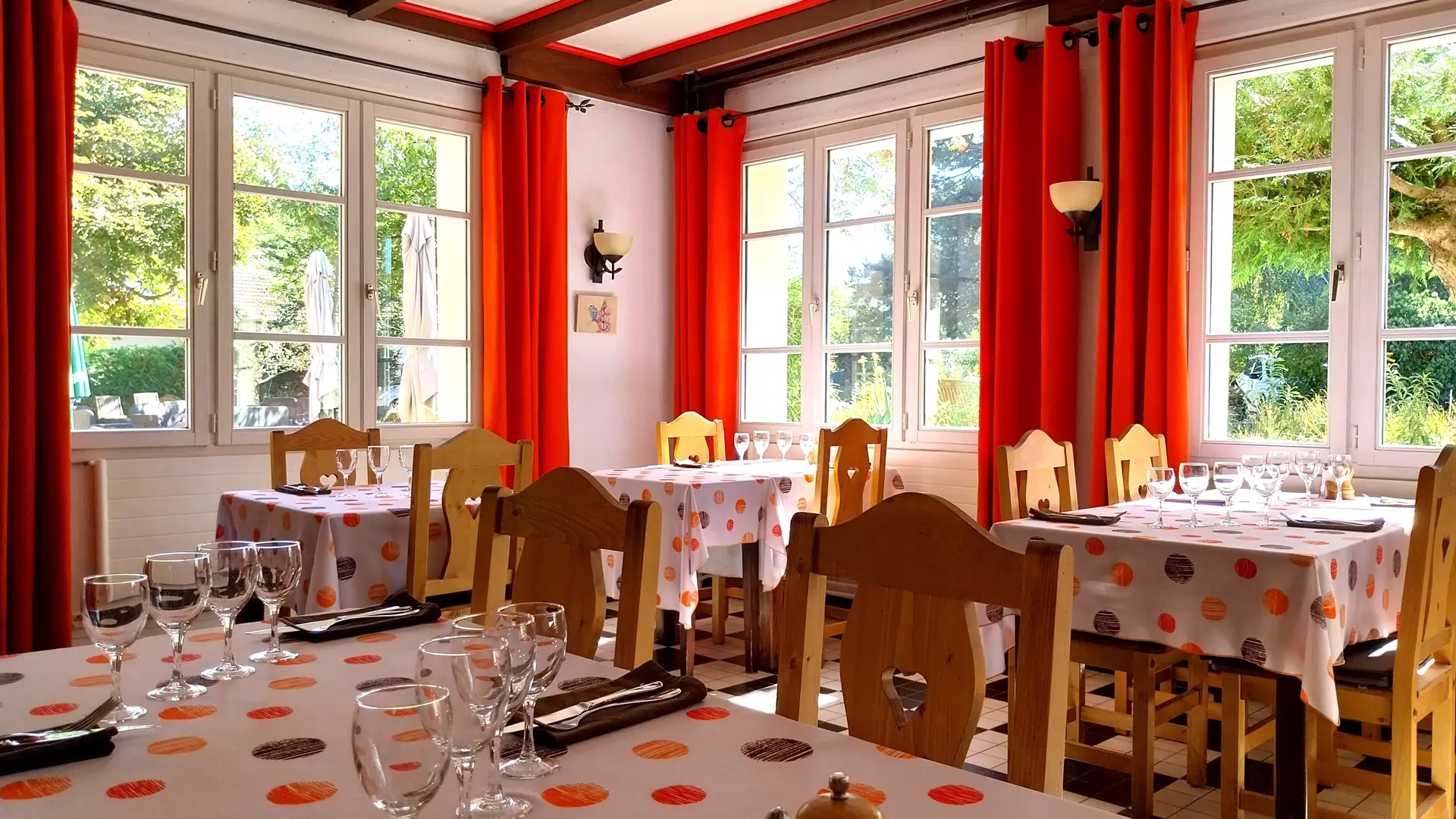 Tables dressées dans une salle de restauration baignée de lumière
