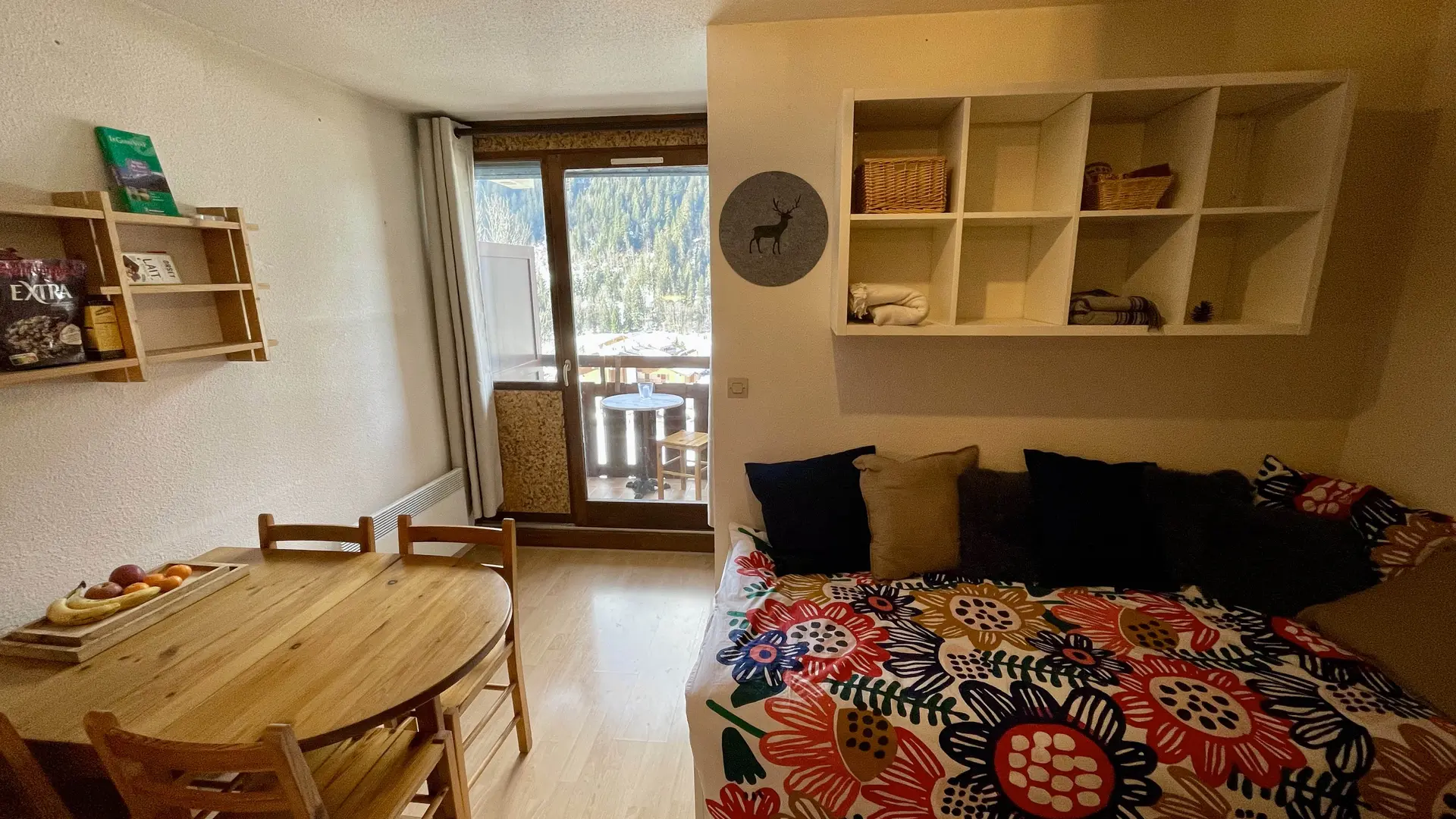 Séjour avec table à manger, canapé, étagères, vue sur balcon