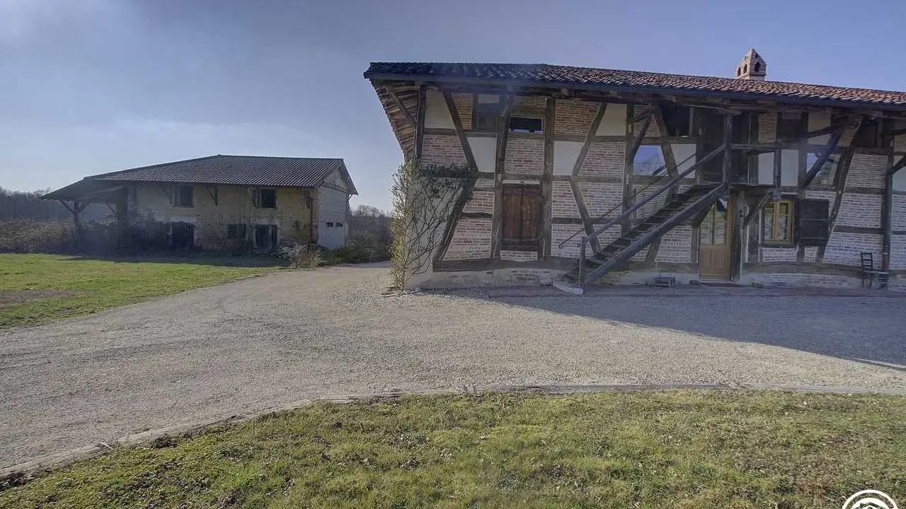 La ferme rénovée avec, en arrière plan, les anciens bâtiments agricoles