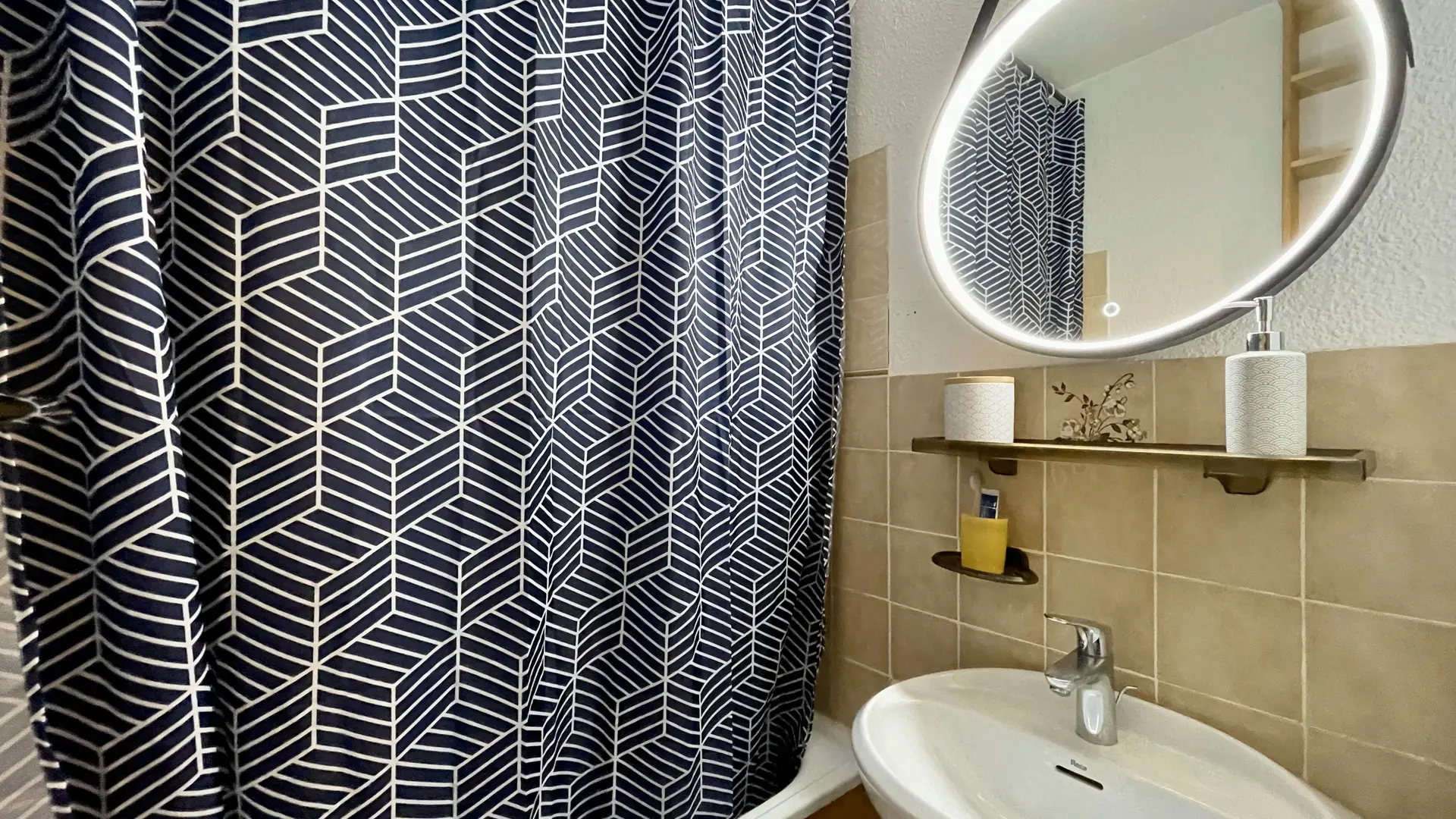 Lavabo avec tablette et miroir au-dessus, rideau de la douche tiré