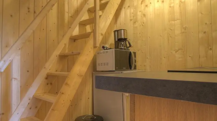 Au pied de l'escalier, qui mène à la mezzanine,  se situe la kitchenette.