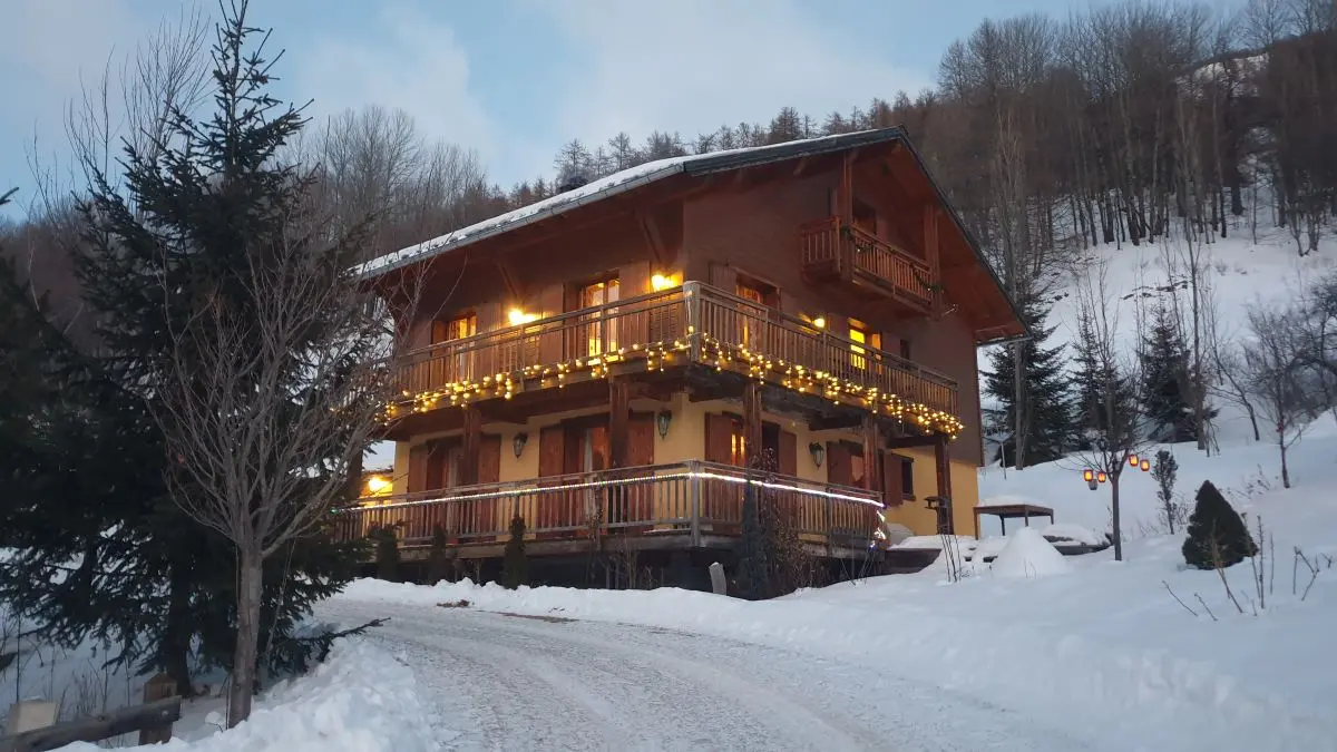 Vue du chalet à double appartement sur 3 étages, excentré au milieu de la nature enneigée