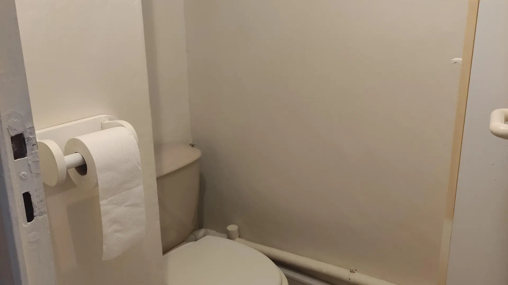 Toilettes avec dévidoir papier sur la droite.