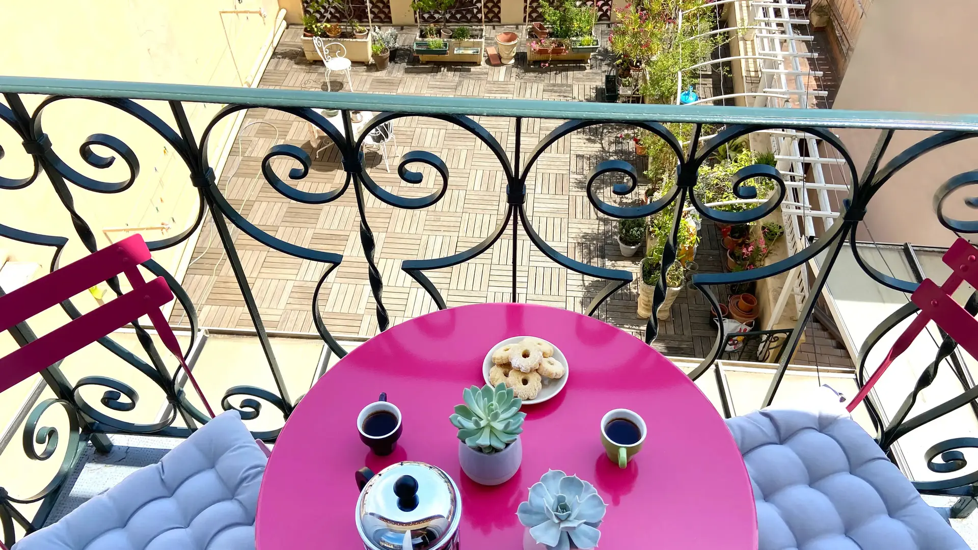 Yolaine et Marcel_L'Isle-sur-la-Sorgue balcon avec table ronde rose et 2 chaises