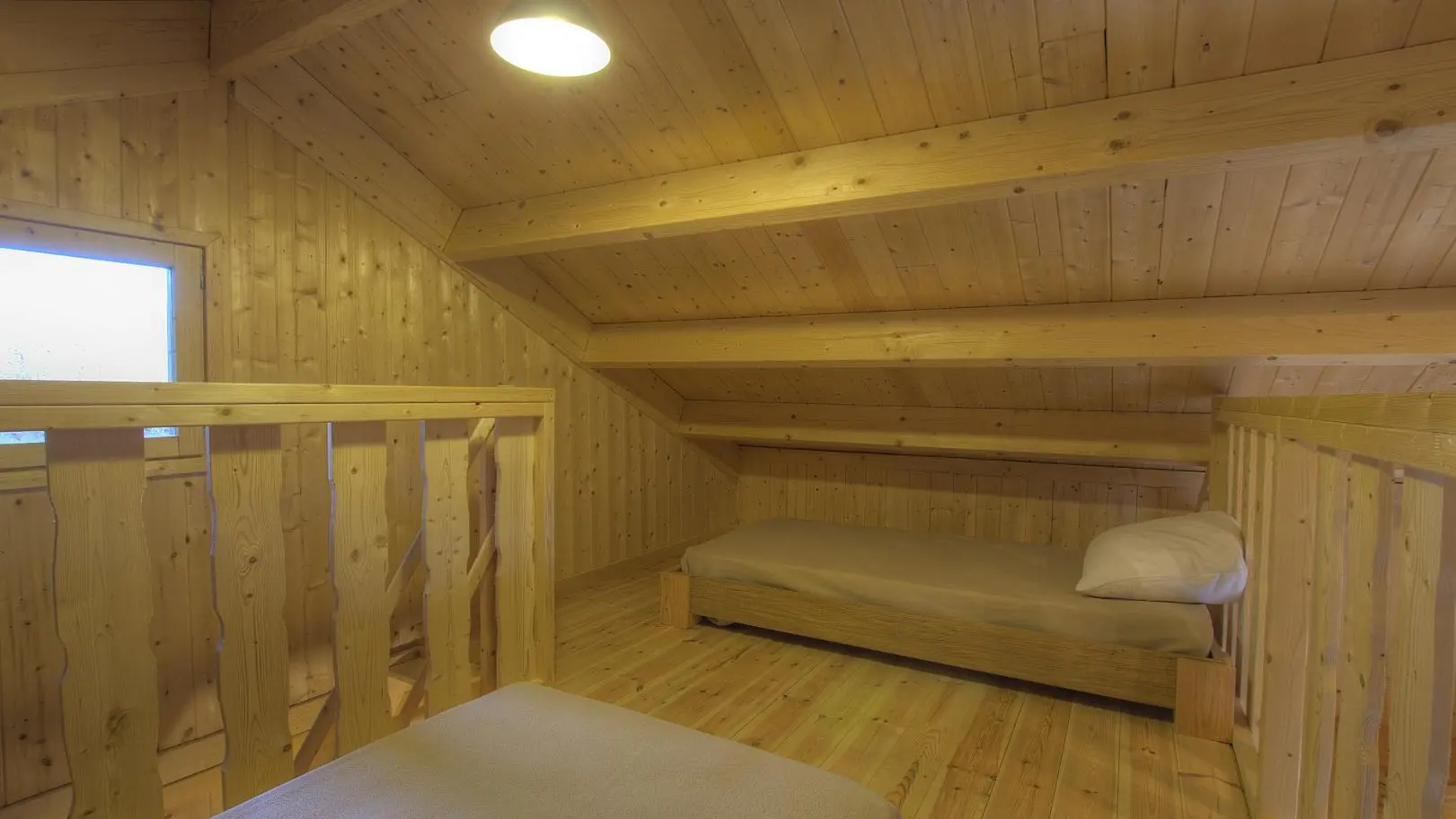 La mezzanine comprends deux lits simples, et elle est ouverte sur la pièce de vie.