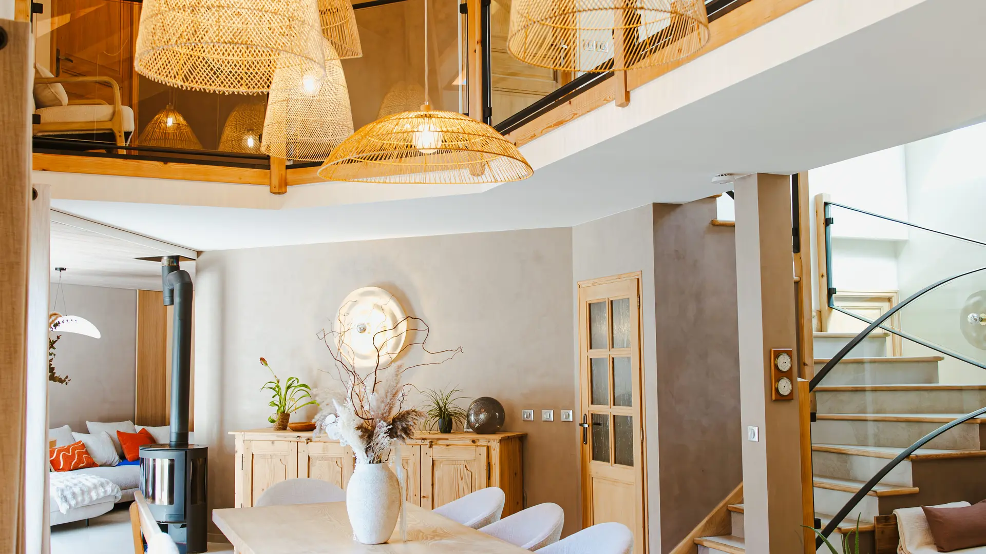 Salle à manger avec plafond haut et plusieurs luminaires suspendus