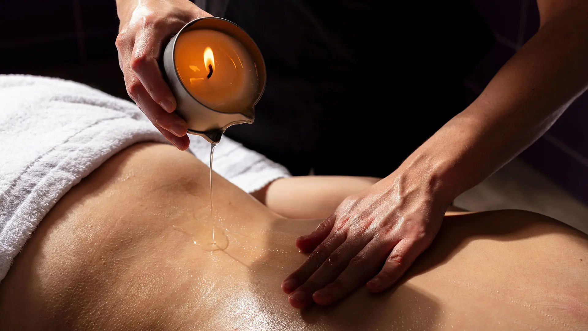 Une personne reçoit un massage à la bougie.