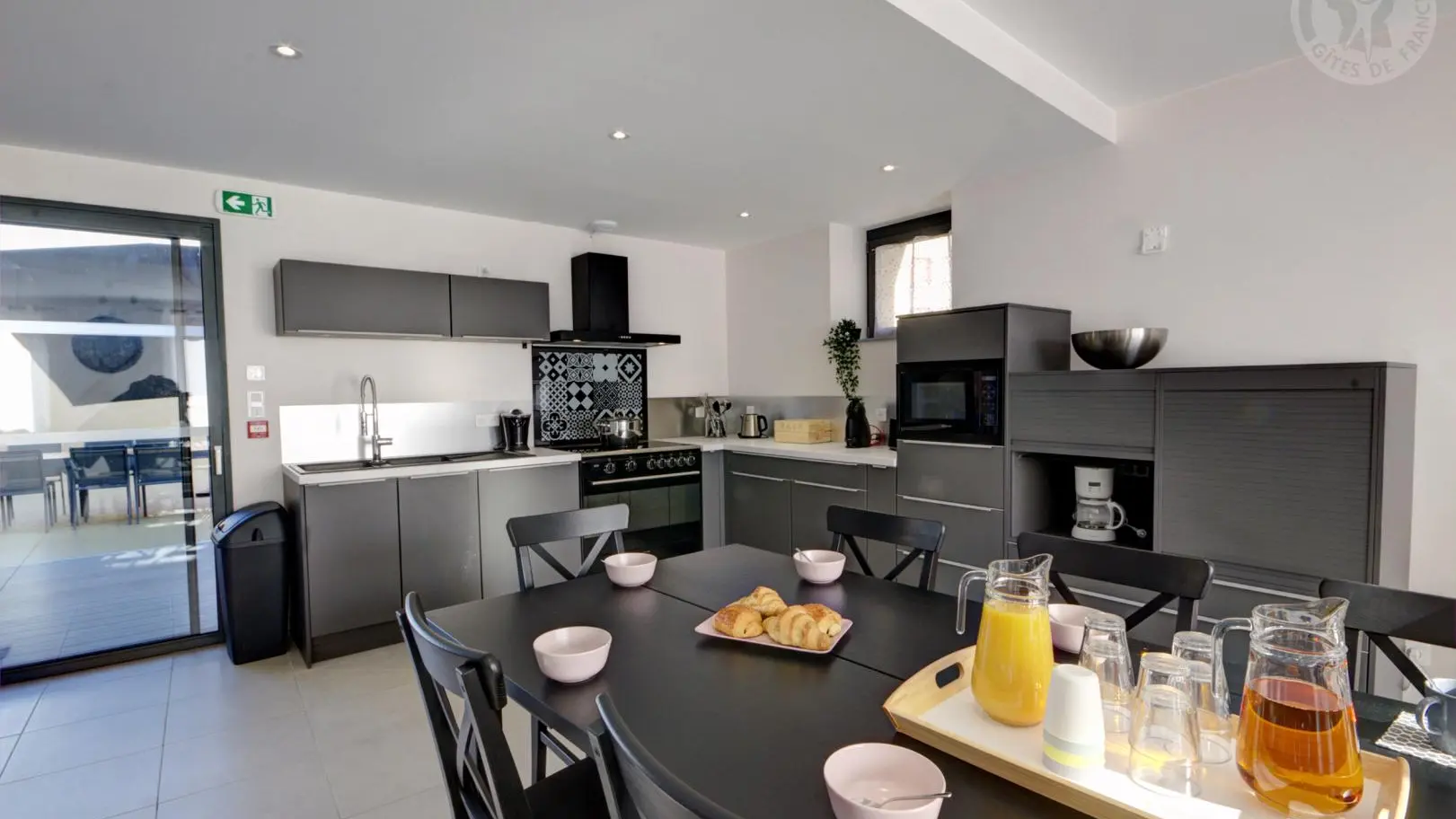 Pièce à vivre avec cuisine ouverte sur la salle à manger et accès direct sur la terrasse et le jardin.