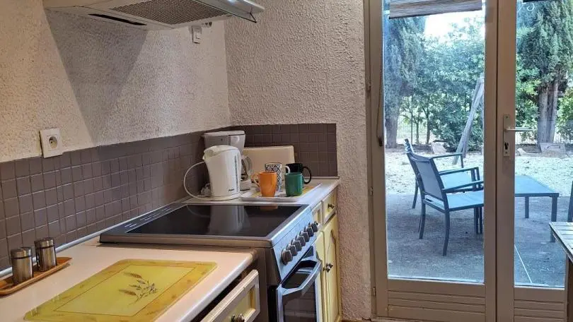 Cuisine ouverte donnant sur terrasse et jardin clôturé .