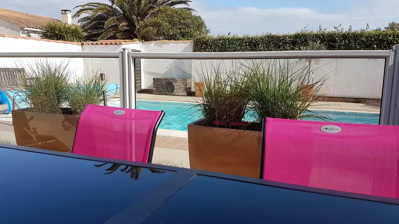 Terrasse équipée d'un salon de jardin et un barbecue