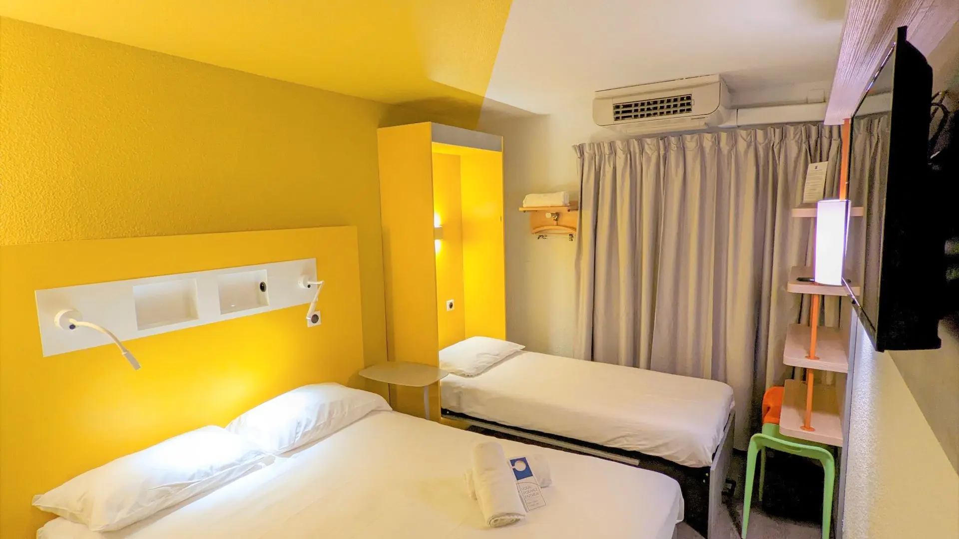 chambre triple un grand lit et un lit simple mur jaune
