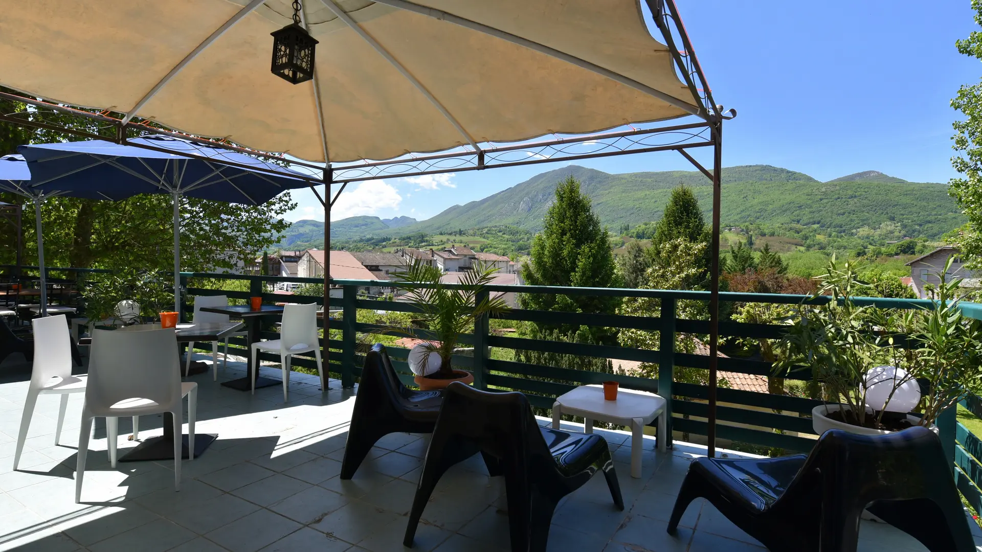 Trois tables accompagnées de leurs chaises vous accueillent pour un moment de détente à l’ombre d’une pergola