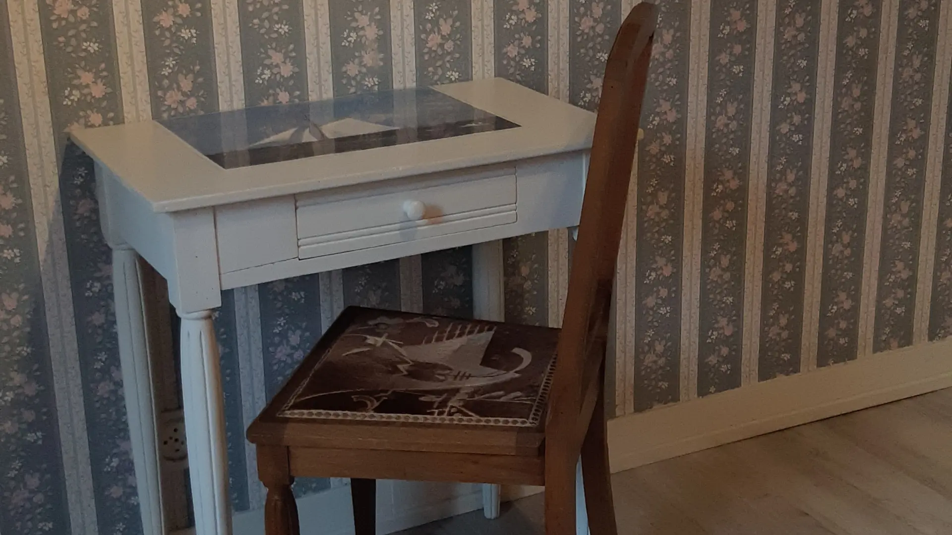 La chambre est meublée d'un lit et d'un bureau avec une chaise.