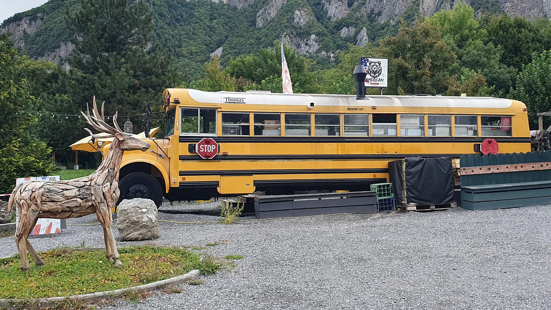 bus jaune restaurant et sculpture cerf en bois