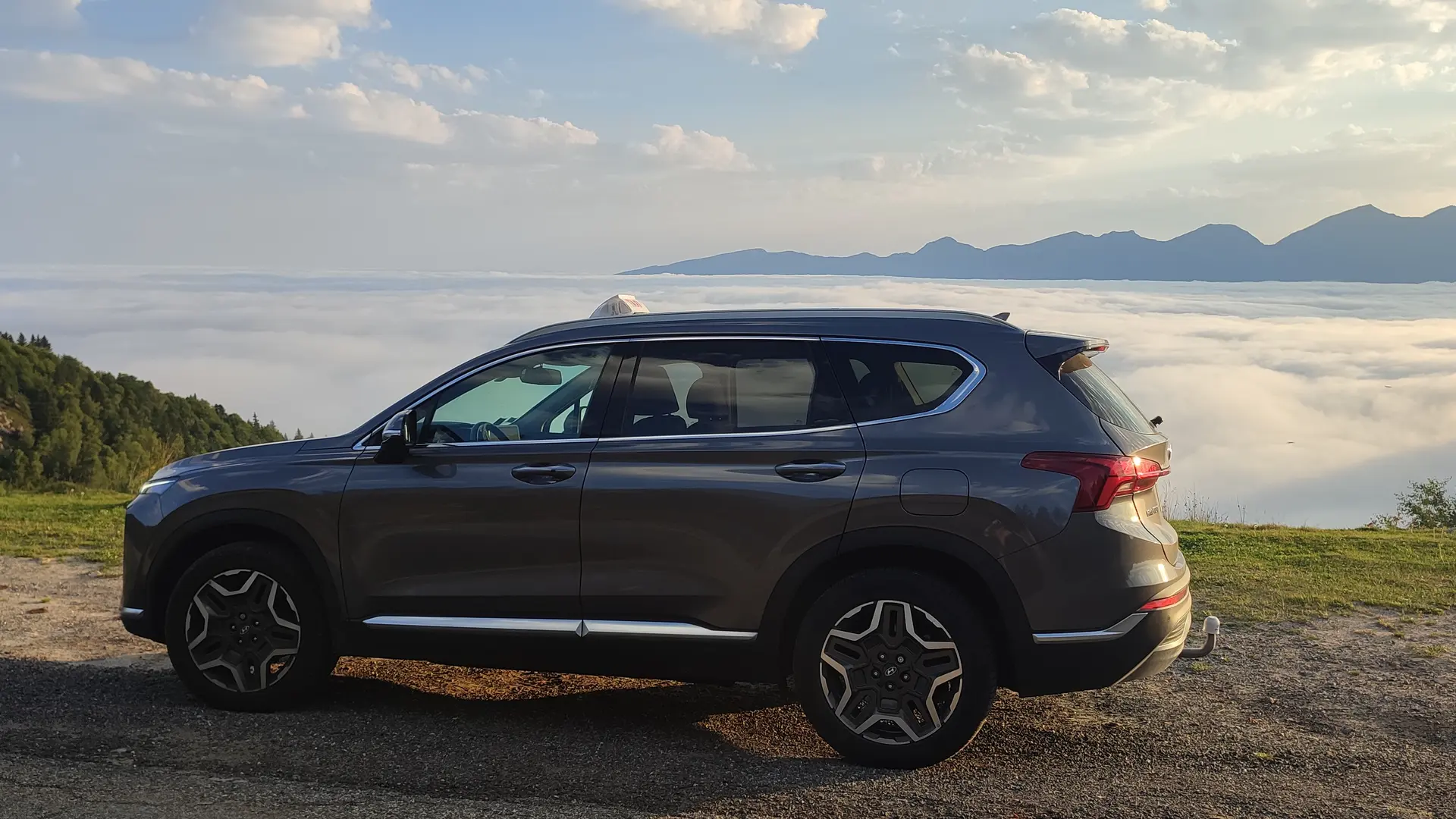 voiture en premier plan avec mer de nuages en arrière plan