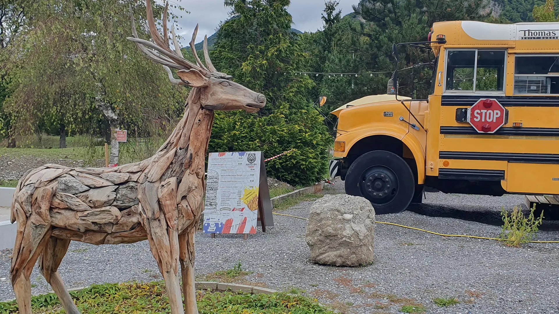 bus jaune restaurant et sculpture cerf en bois