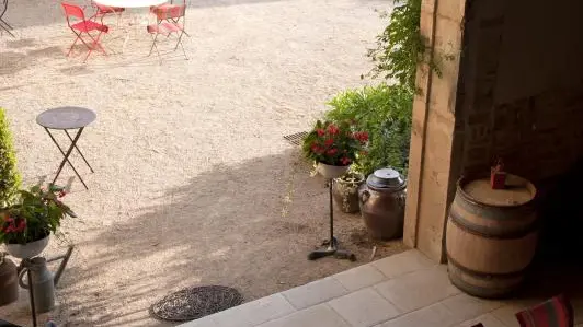 Le chemin vous amène au préau, lieu de vie semi ouvert sur le jardin