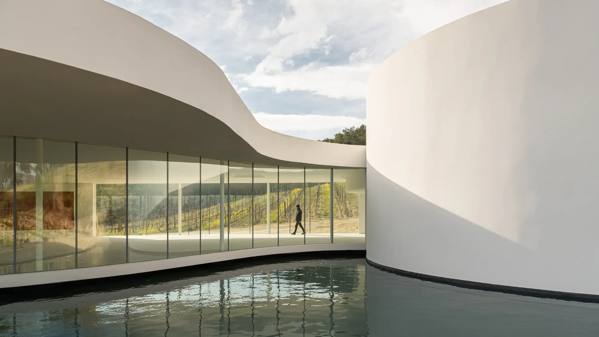 The white pavilion designed by Oscar Niemeyer, set on the edge of a reflecting pool. Oscar Niemeyer, the Pavilion, Château La Coste. Photo © Stéphane Aboudaram / WeAreContent(s)