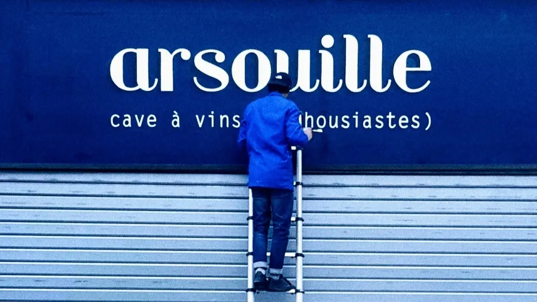 devanture avec homme sur une echelle rideau baissé