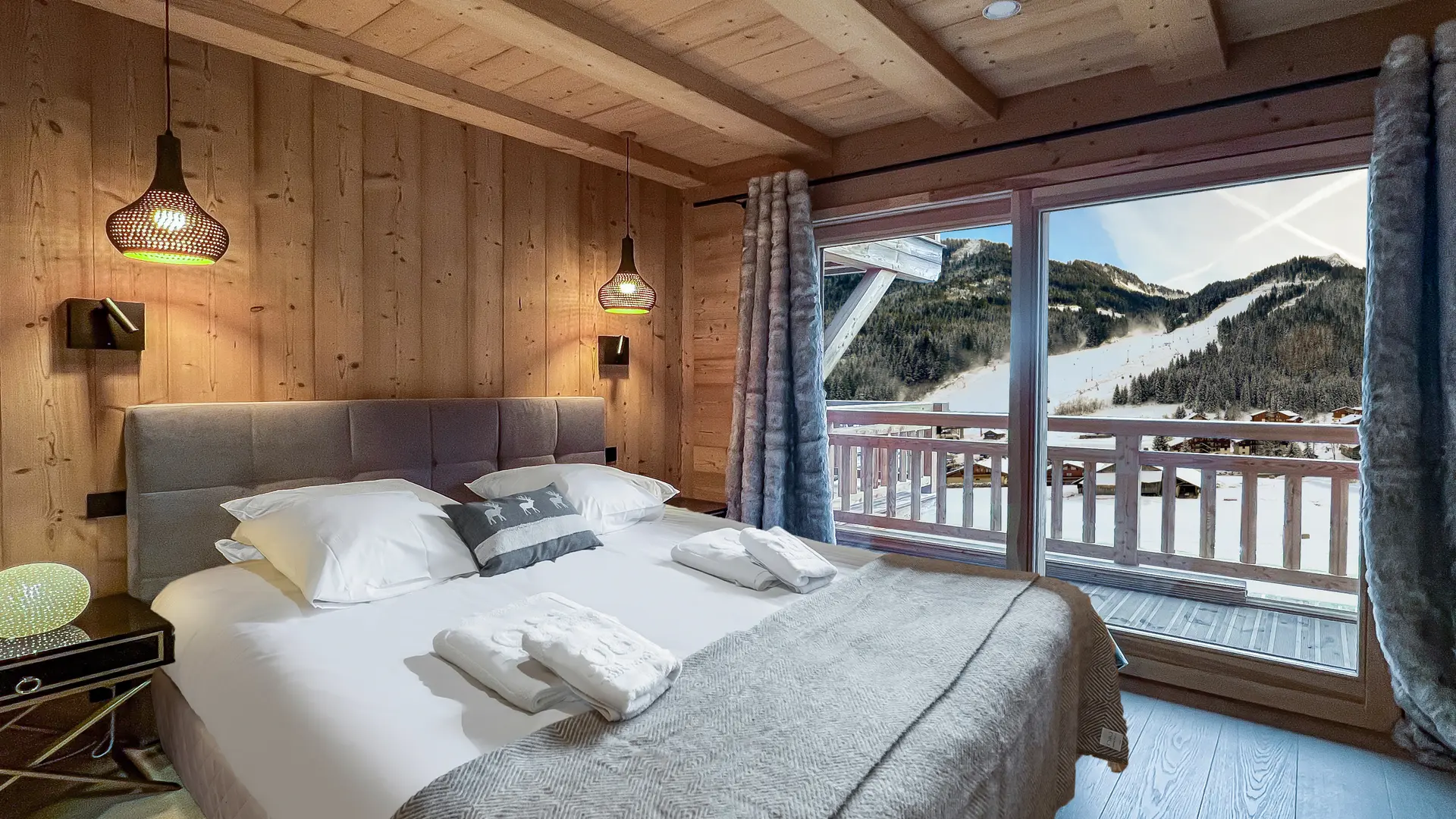 Chambre double avec grande baie vitrée donnant accès au balcon, vue sur les pistes du Linga