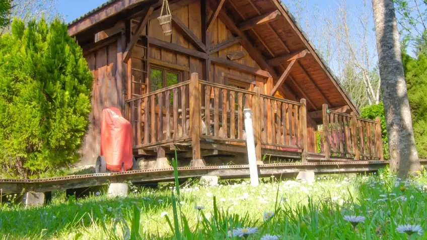 Situé dans un environnement naturel, ce chalet présente une structure en bois caractéristique.