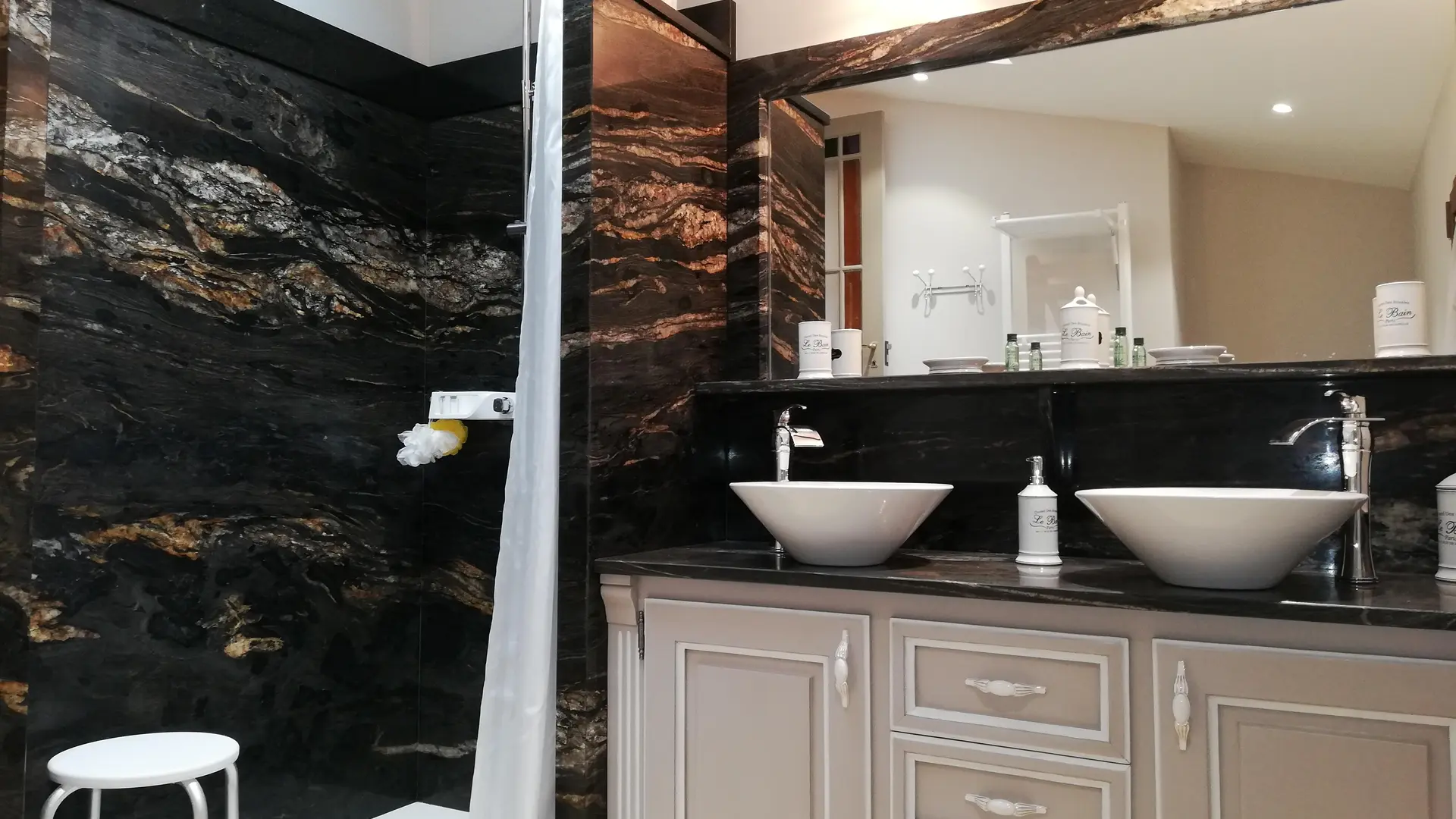 Une salle de bain moderne avec douche à l’italienne et double vasque dans un style élégant.