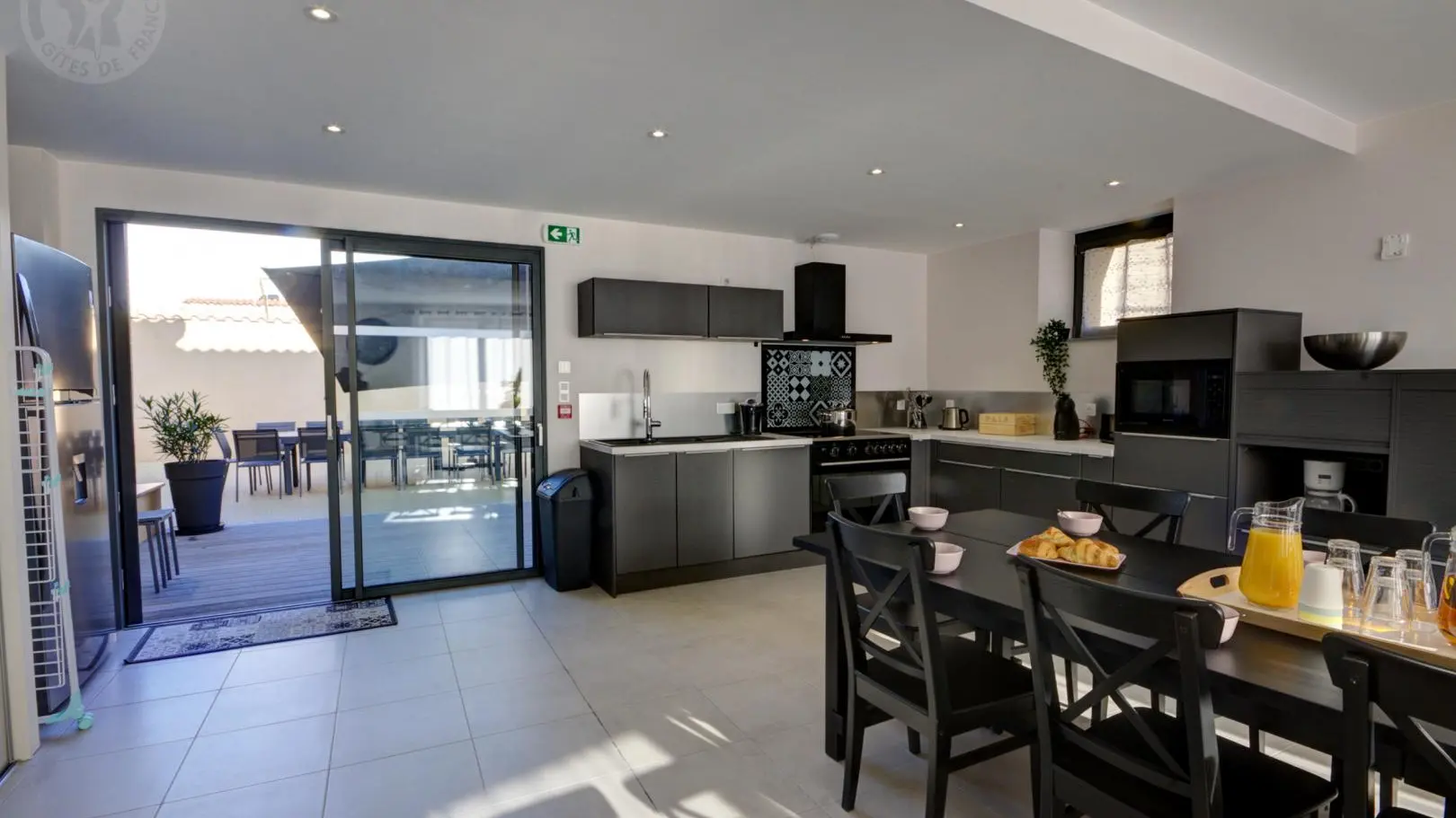 Pièce à vivre avec cuisine ouverte sur la salle à manger et accès direct sur la terrasse et le jardin.