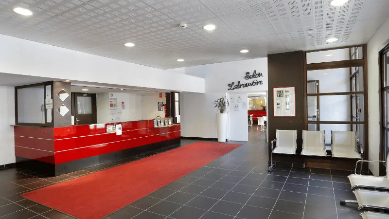 Residence reception area, tiled floor, reception desk, waiting chairs, door to lounge