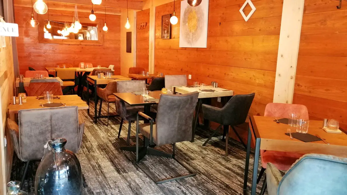 Salle intérieure du restaurant, tables et chaises, ambiance lumineuse et confortable