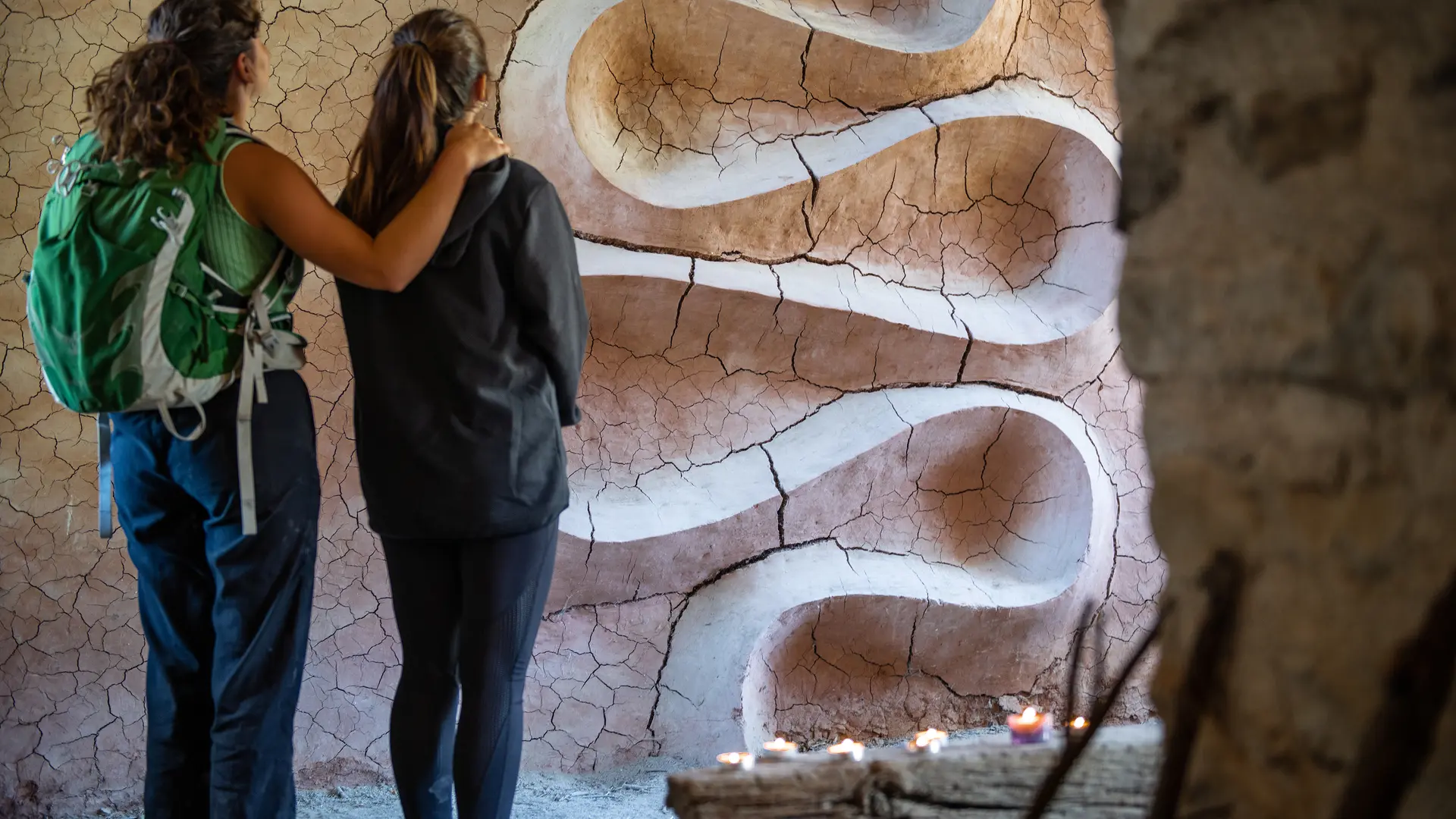 Walkers reaching the cracked clay wall of Refuge d'Art Vieil Esclangon. Andy Goldsworthy, Refuge d'Art – Vieil Esclangon, 2005, collection Art en montagne du musée Gassendi. Photo © lenaturographe