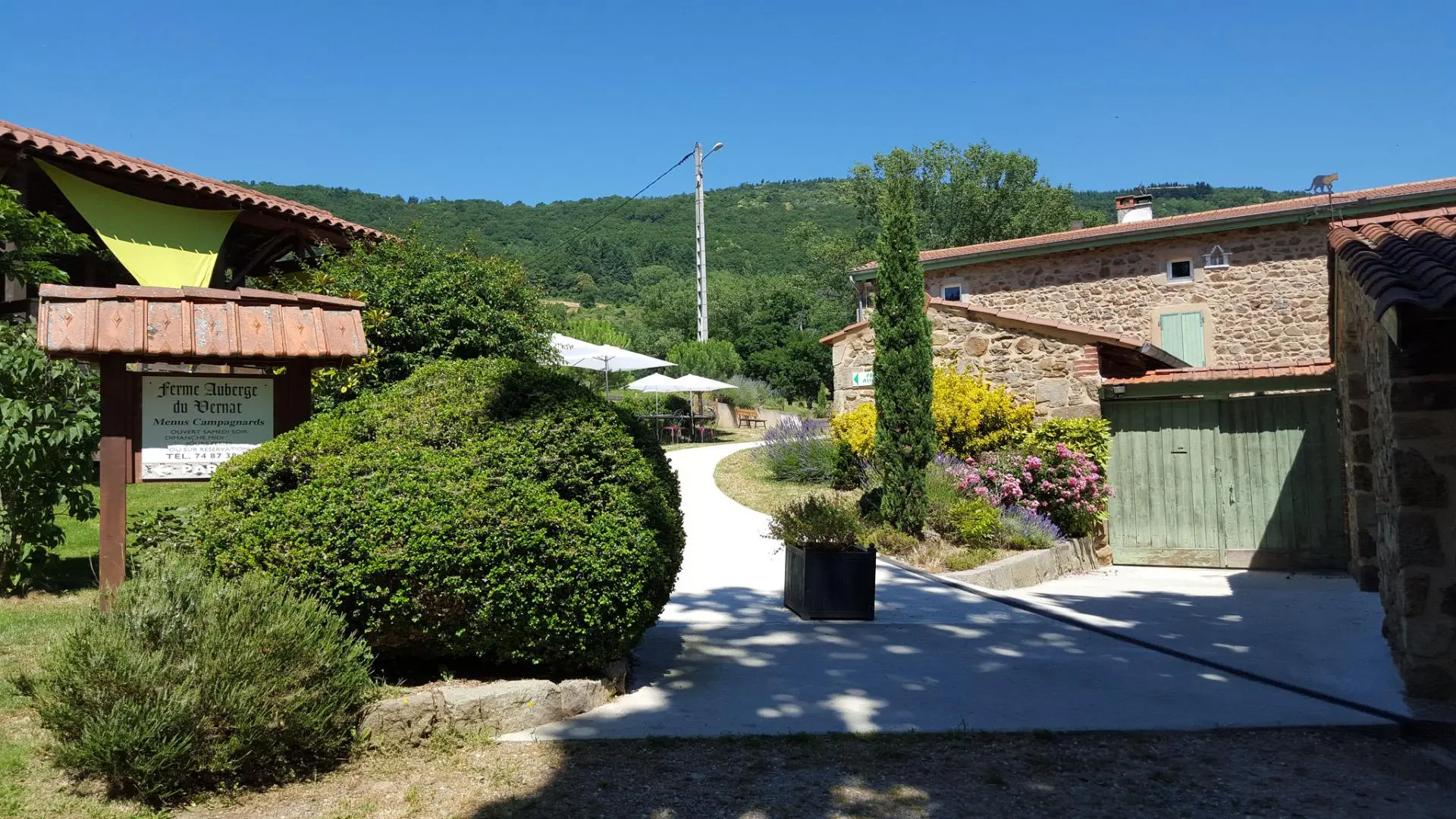L'entrée du gîte (portail vert) et l'entrée de l'auberge (sur la gauche)