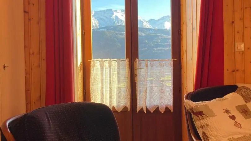 Porte-fenêtre du coin salon donnant accès au balcon orienté sud et vue sur le massif du Bargy.