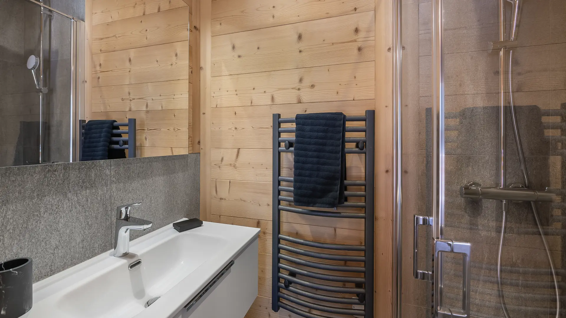 Salle de bains avec grande vasque et son meuble, grand miroir, sèche serviettes, douche