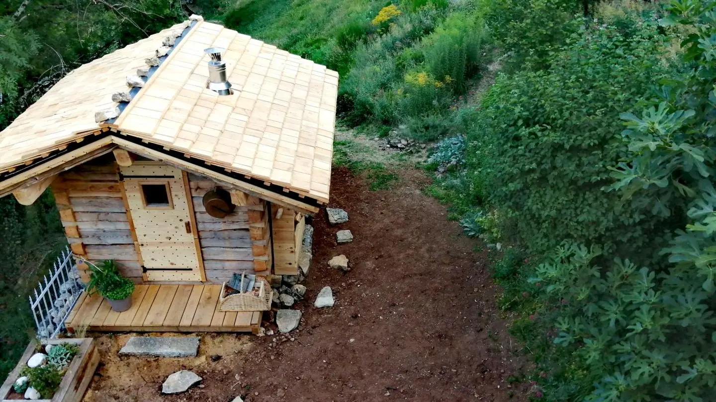 Le sauna en bois brut et son toit de bardeaux