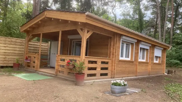 Vue du chalet de l'extérieur avec la terrasse et l'entrée