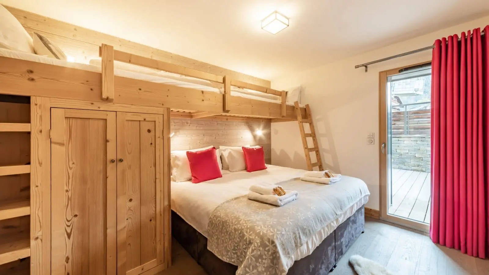 Chambre familiale avec un lit double et deux lits superposés ambiance cosy chaleureuse de montagne