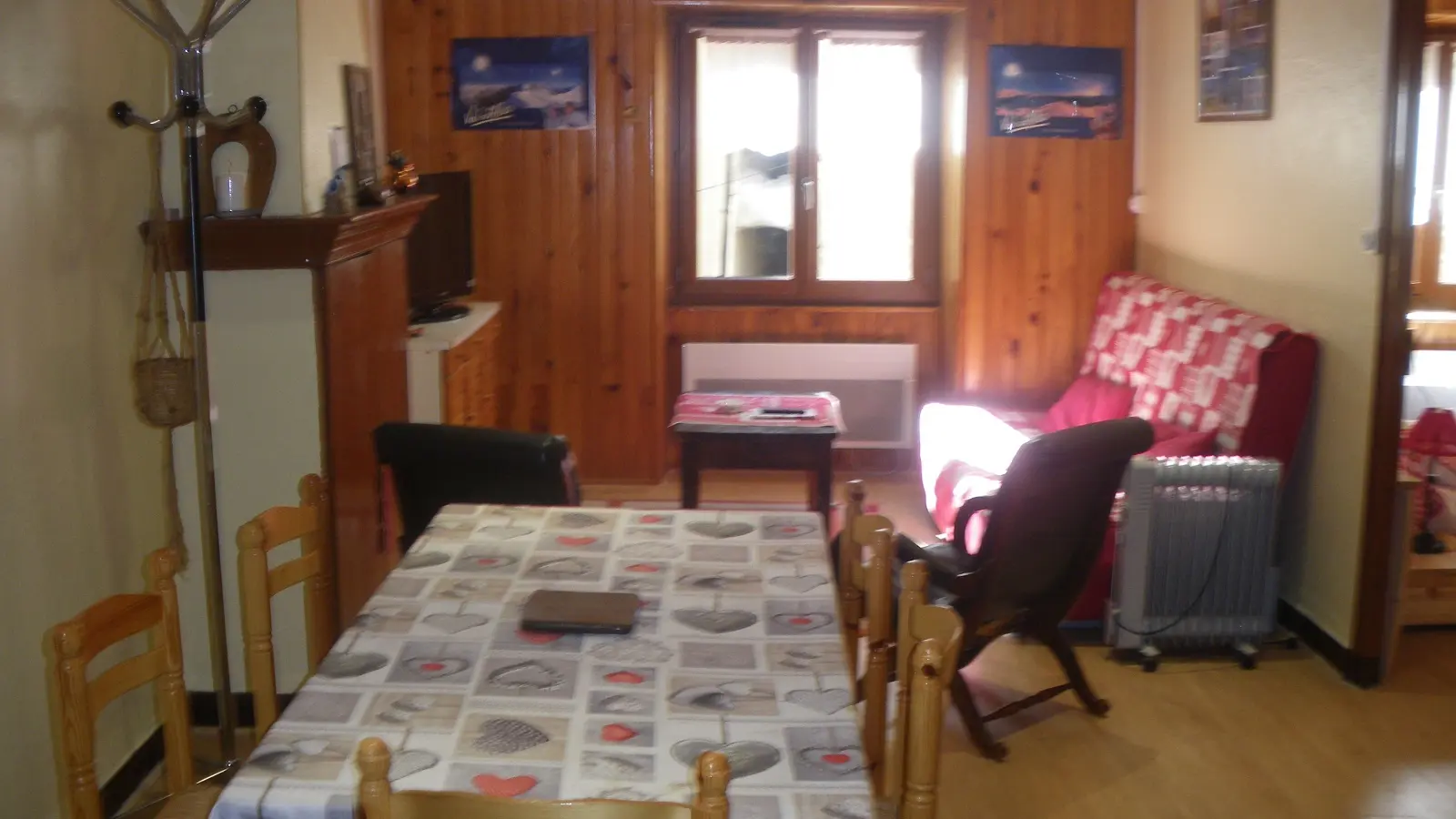 Coin séjour avec table à manger, canapé, TV, ameublement bois, parquet au sol, fenêtre