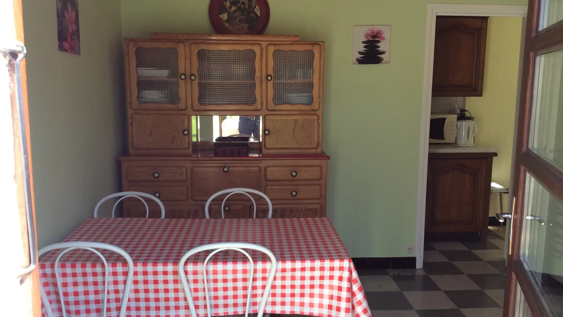 C'est une salle à manger de taille moyenne. Une table rectangulaire, entourée de six chaises, occupe le centre de la pièce. Un buffet est adossé au mur.