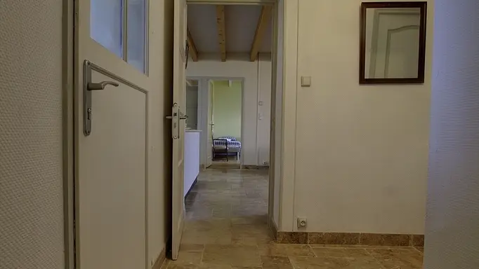 Couloir qui dessert la 3ème chambre, la salle d'eau avec sur la gauche une porte qui mène à la terrasse couverte.