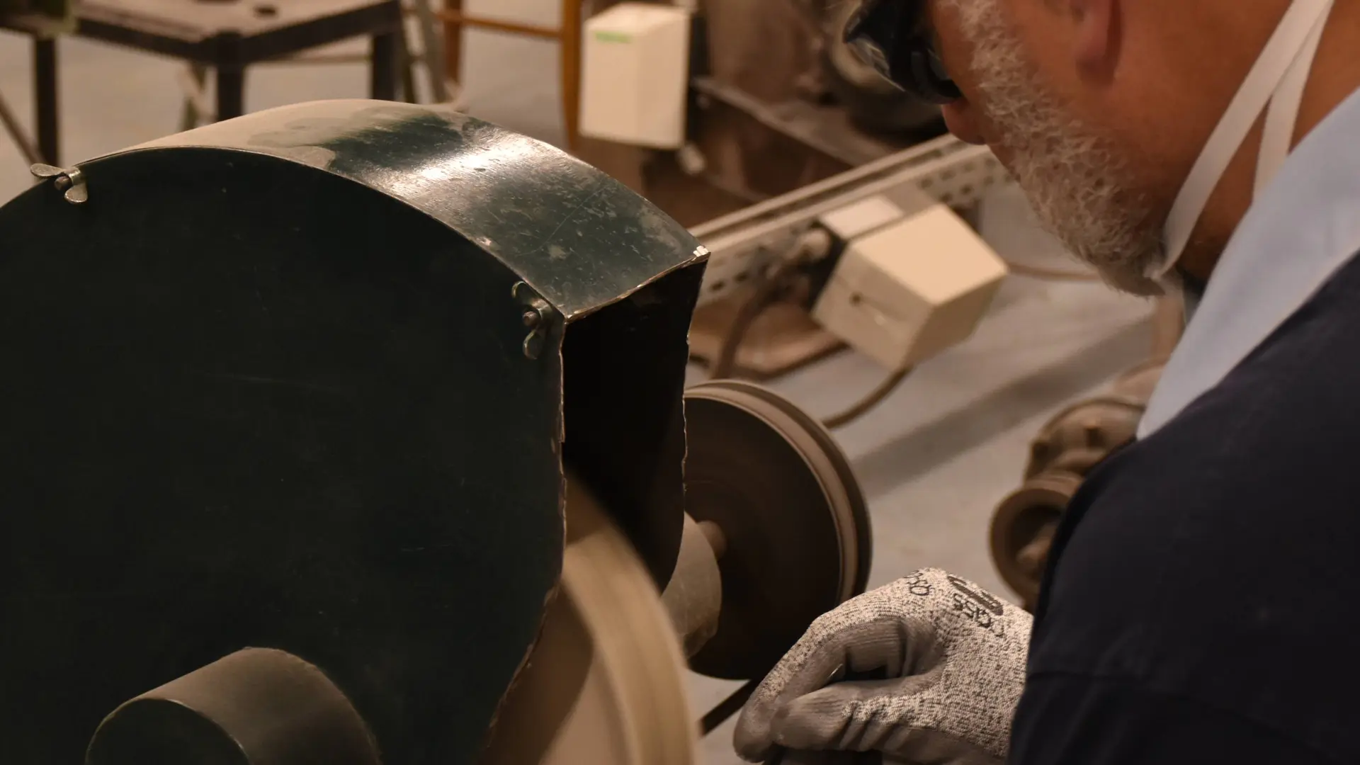 On voit la manière dont le coutelier meule le manche en bois du couteau