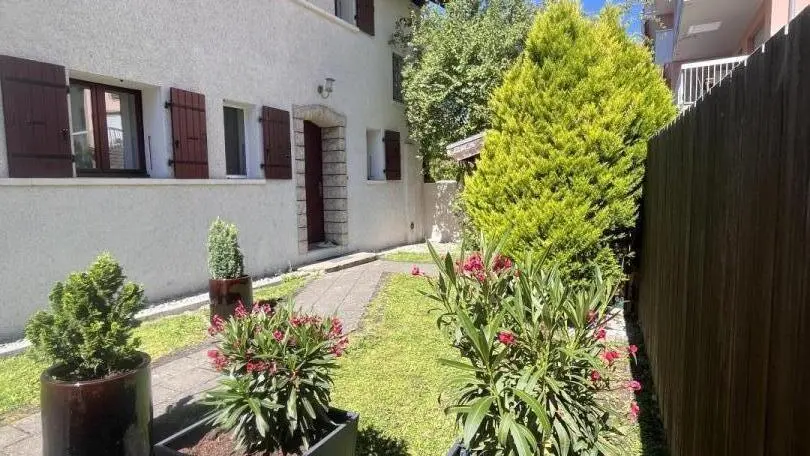 L'entrée de la maison du propriétaire donnant sur un environnement calme et verdoyant