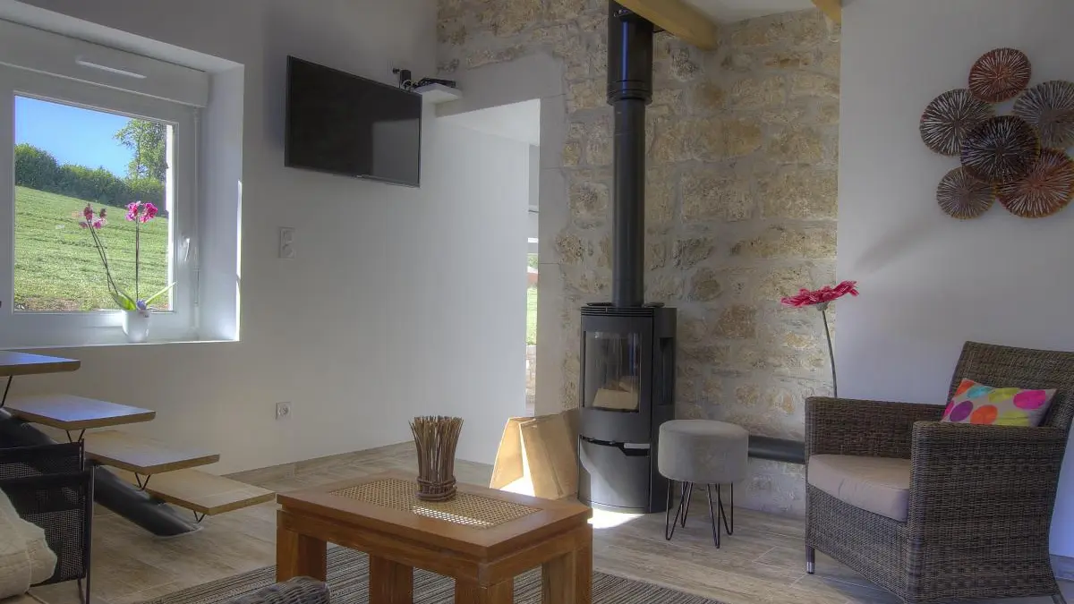 Salon lumineux avec poêle à bois.